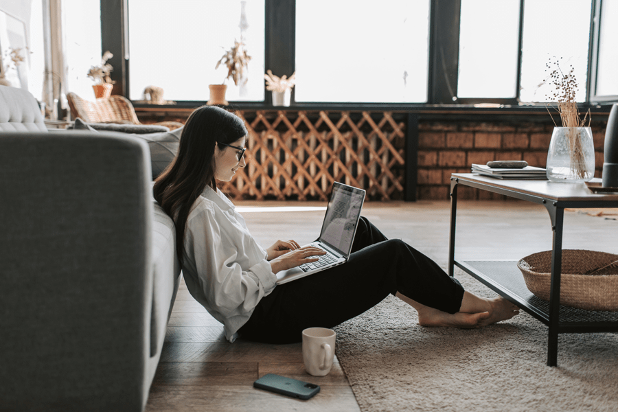 young female using her laptop sitting in a living room